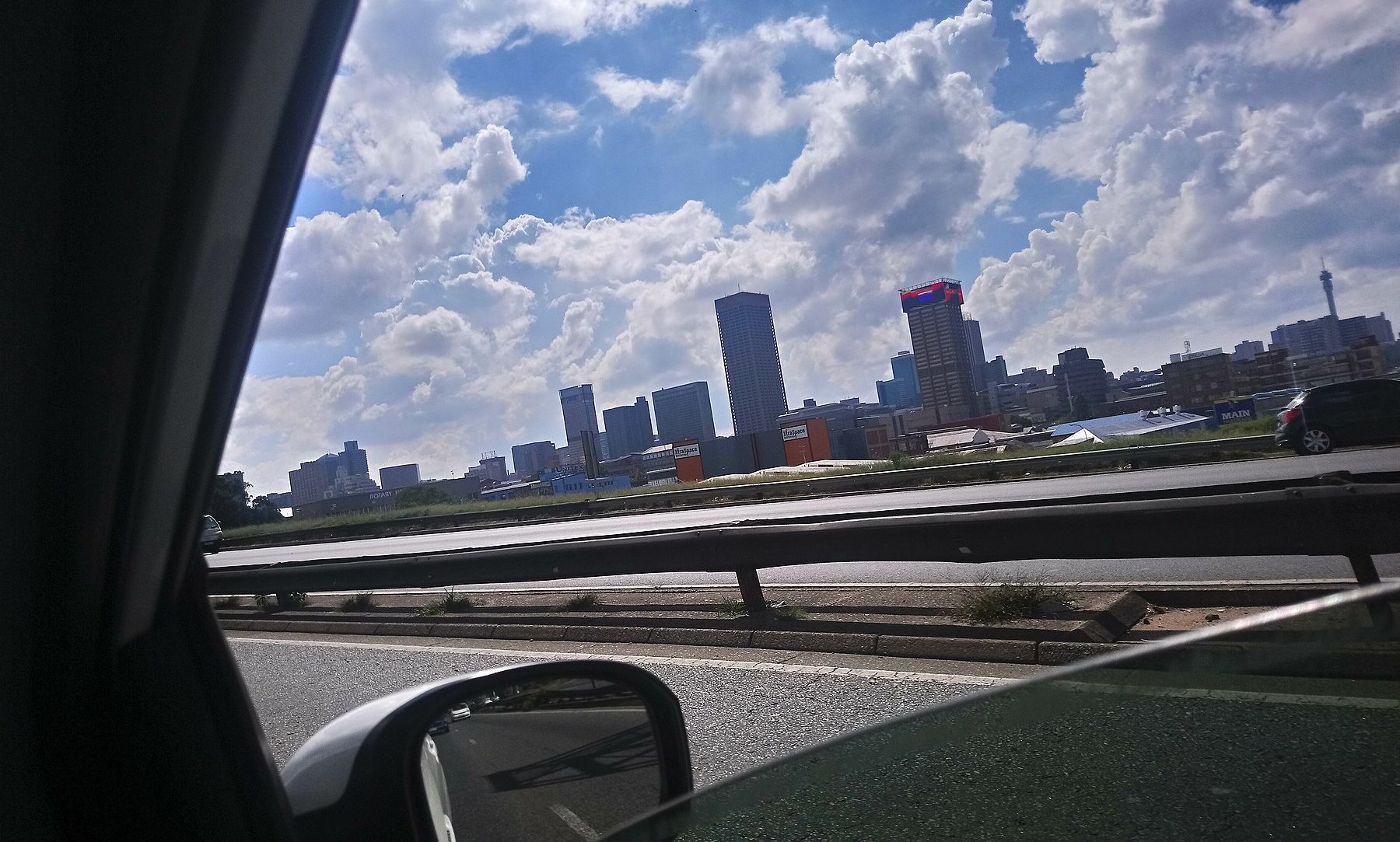 City skyline from a moving car on a highway