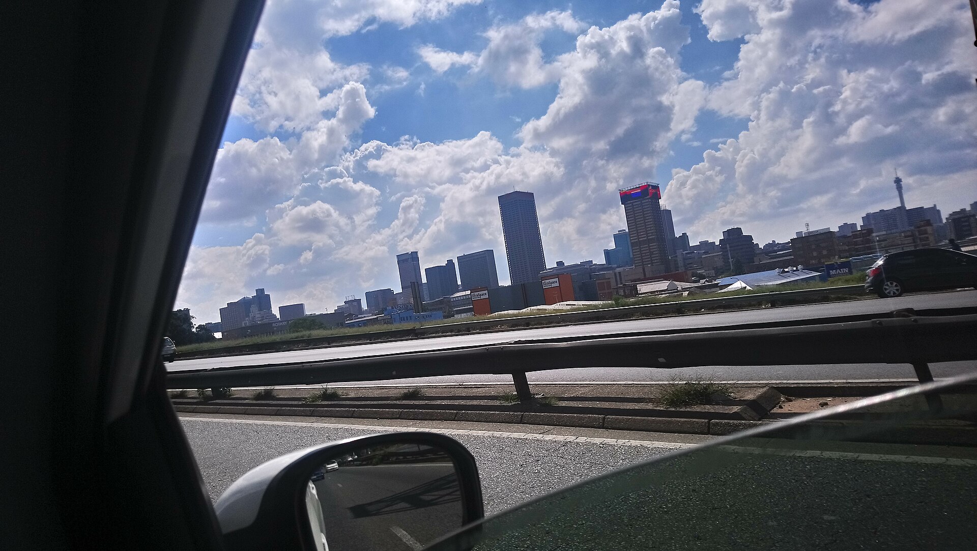 City skyline from a moving car on a highway