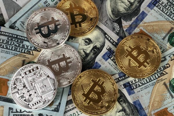 Physical Bitcoin coins on US dollar bills.