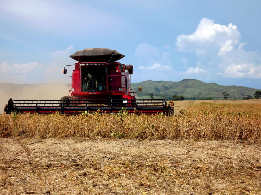 Red combine harvester in a soybean field