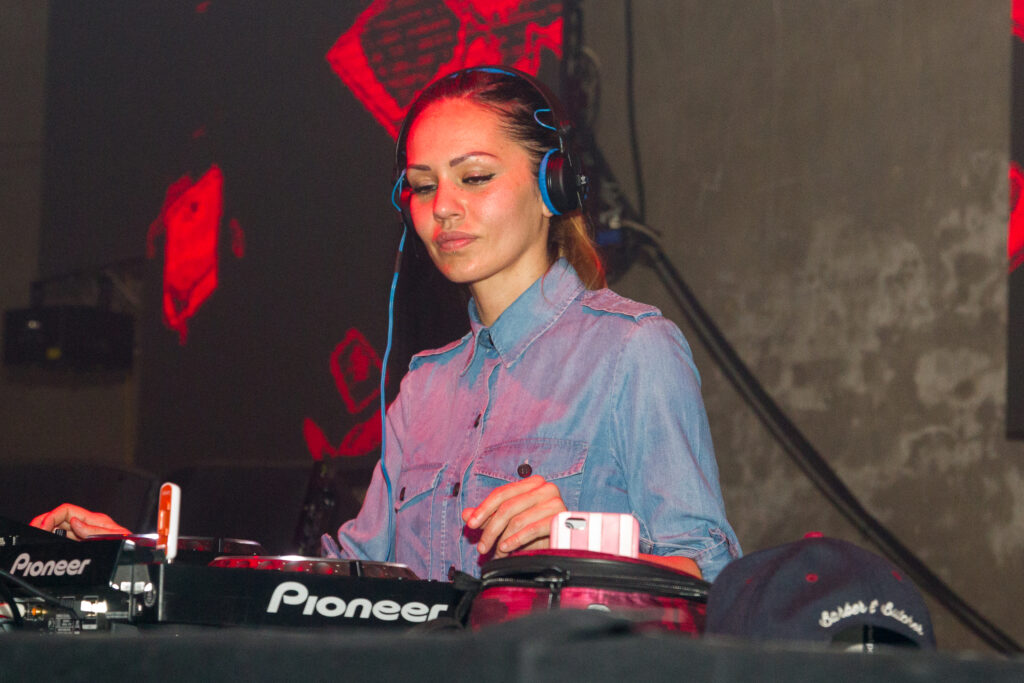 Italian DJ Deborah de Luca performing at the decks in a club