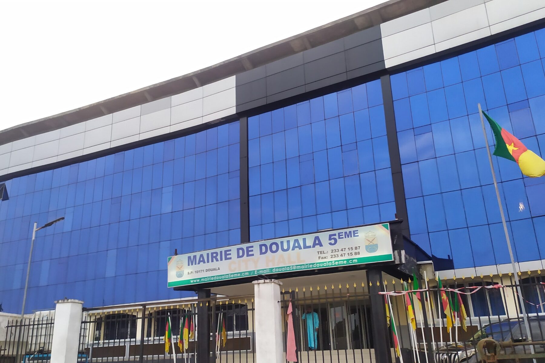 Coris Bank Cameroon entry — modern glass building in Douala with Cameroonian flag