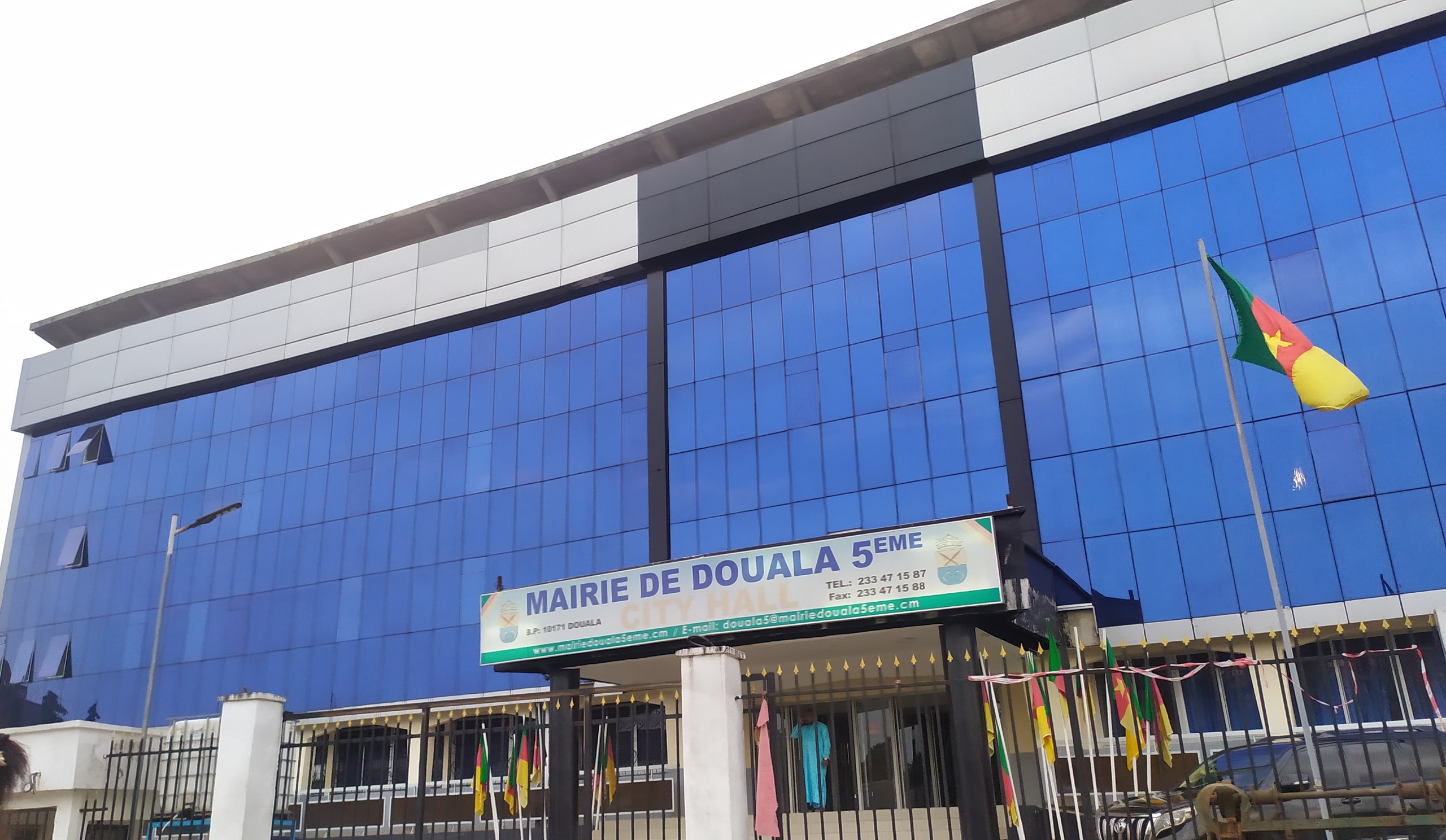 Coris Bank Cameroon entry — modern glass building in Douala with Cameroonian flag