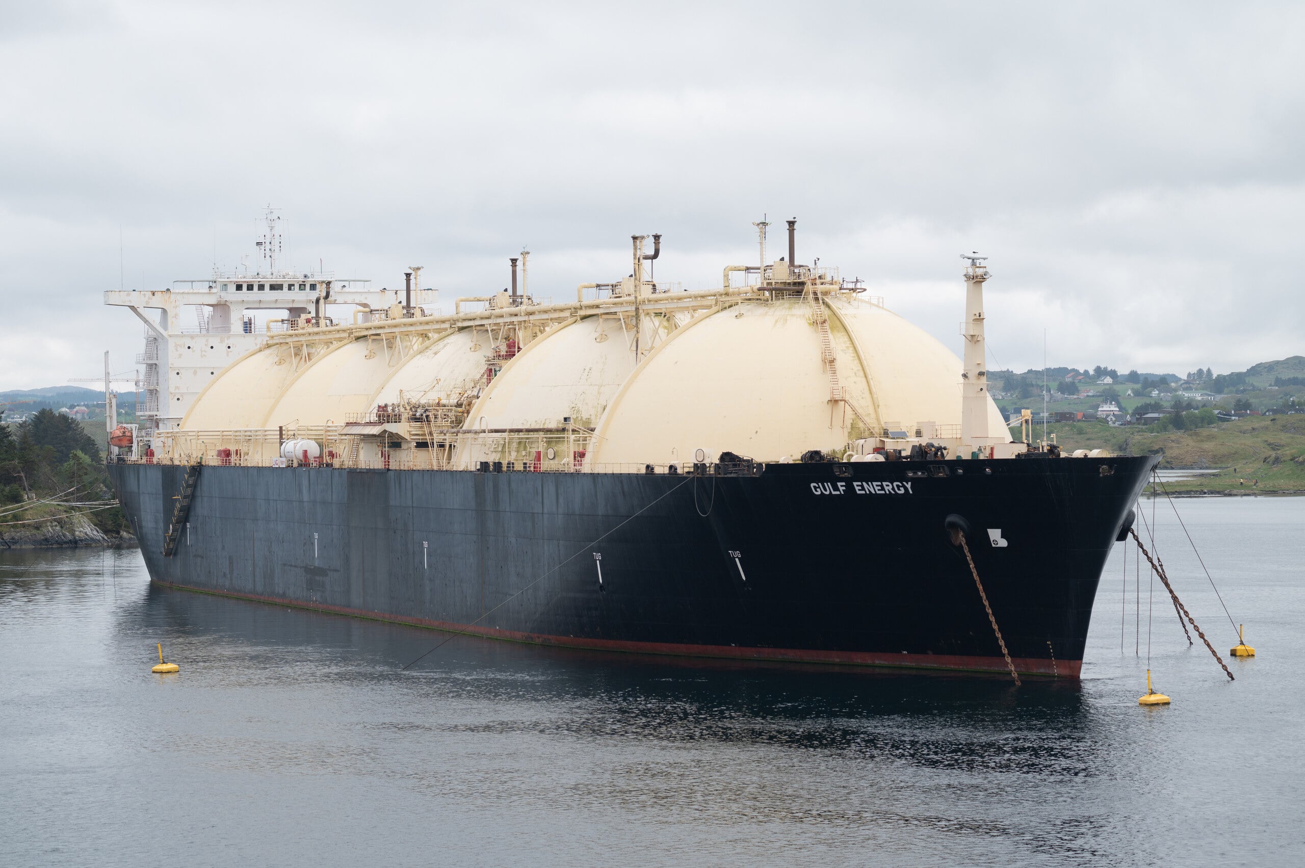 floating LNG plant — an LNG carrier with spherical tanks at anchor