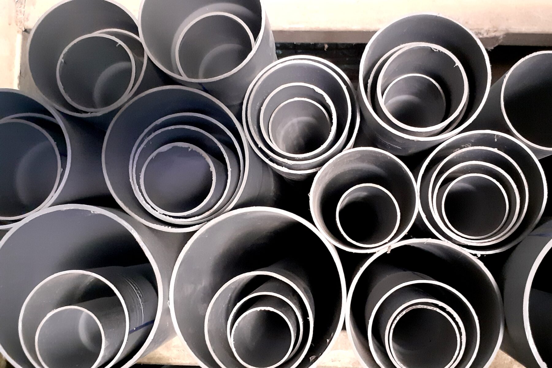 Stacked plastic pipes, illustrating polymer and pipe manufacturing