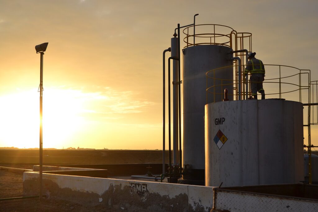 Worker on storage tanks at sunset