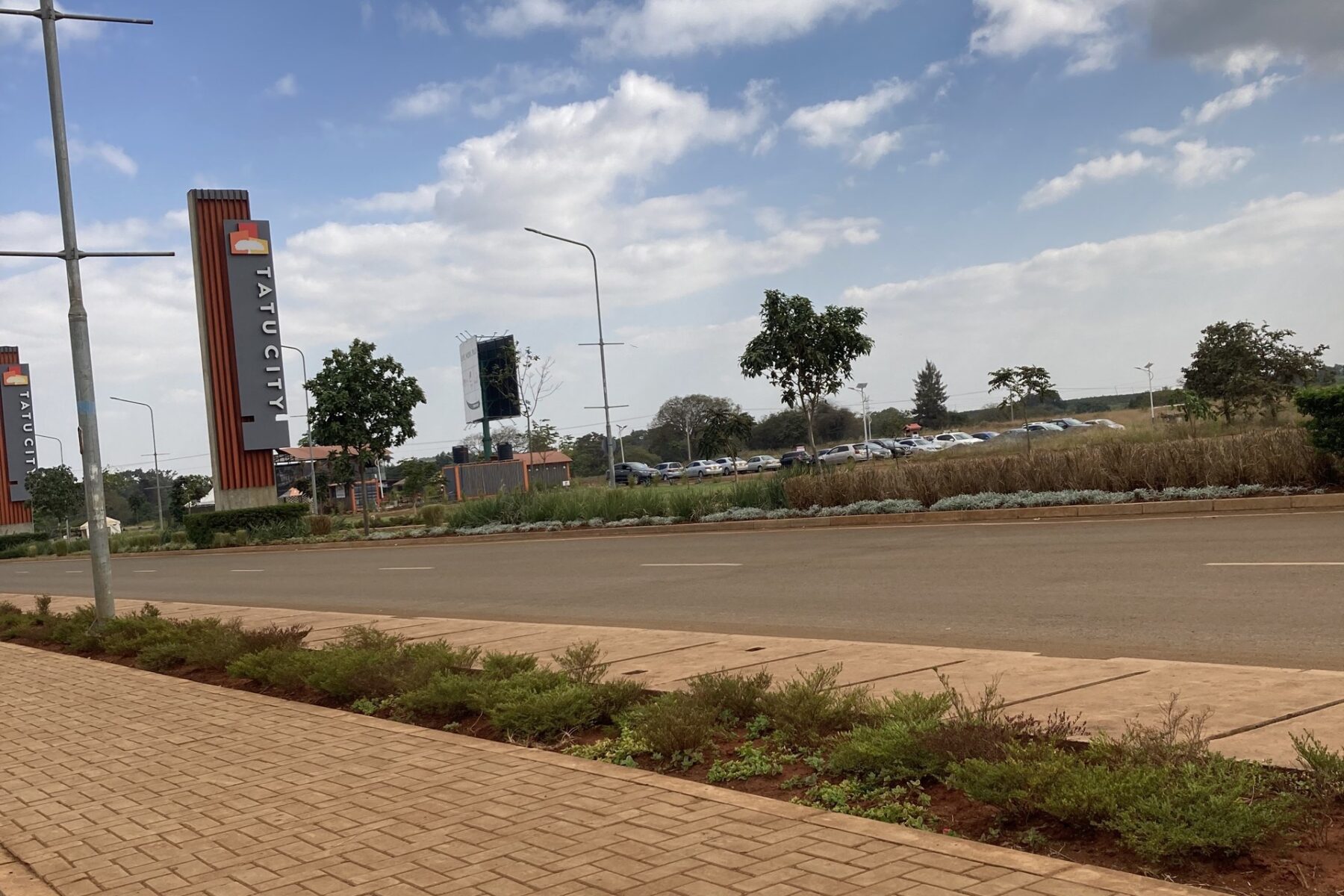 Tatu City entrance road with branded pylons outside Nairobi