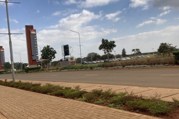 Tatu City entrance road with branded pylons outside Nairobi