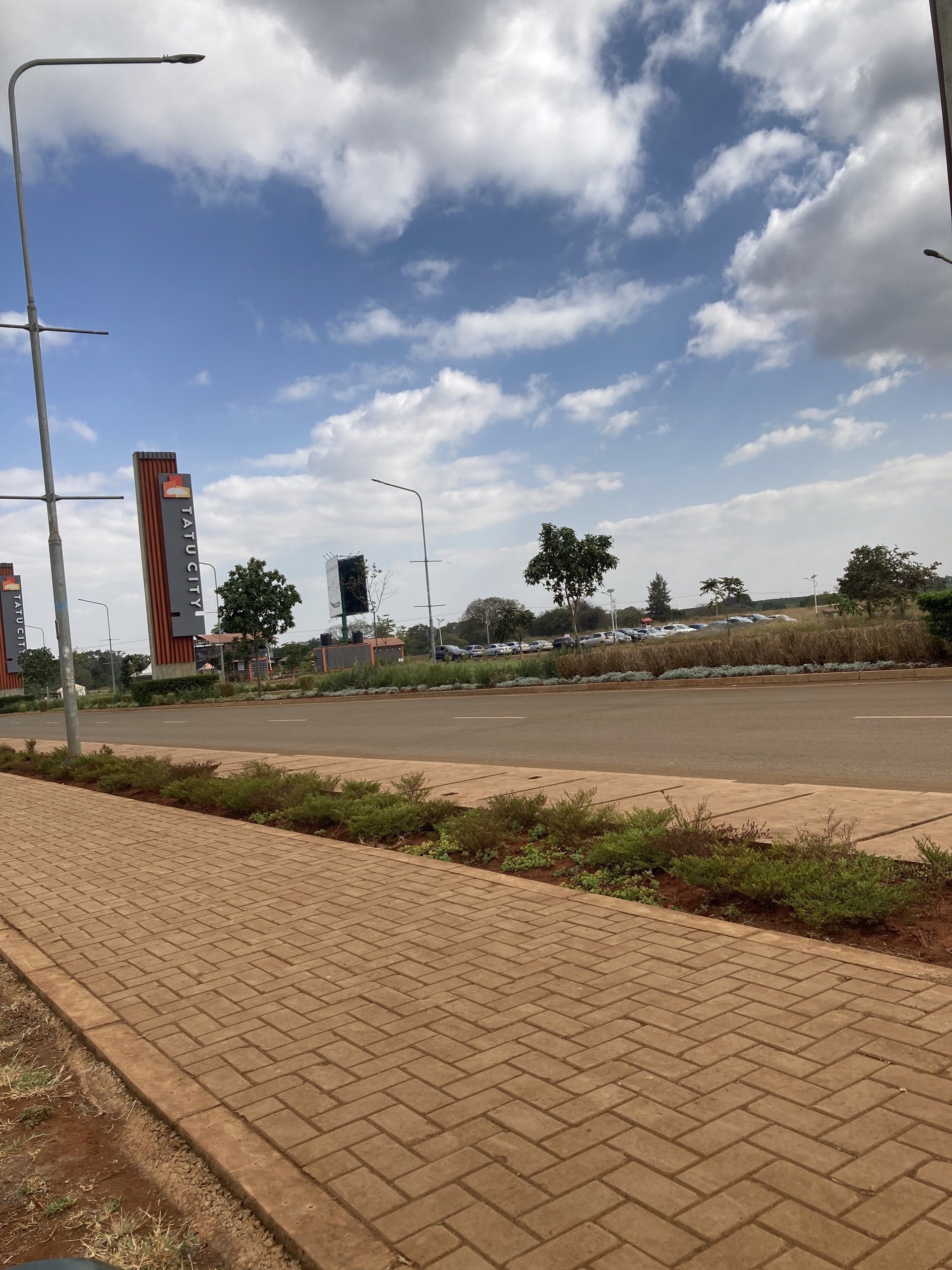 Tatu City entrance road with branded pylons outside Nairobi