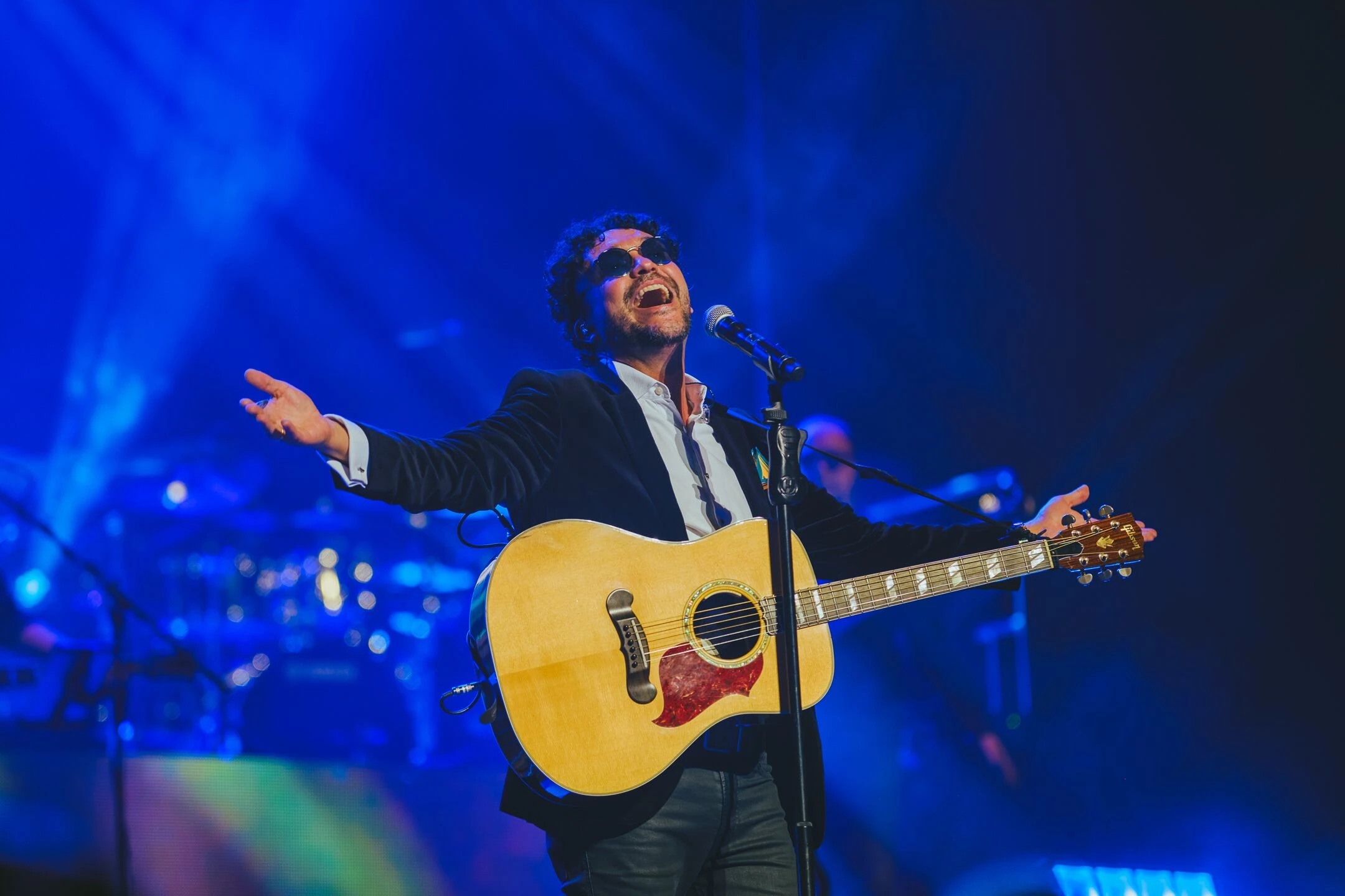 Andrés Cepeda performing live on stage, with a microphone in hand, during his tour in Quito