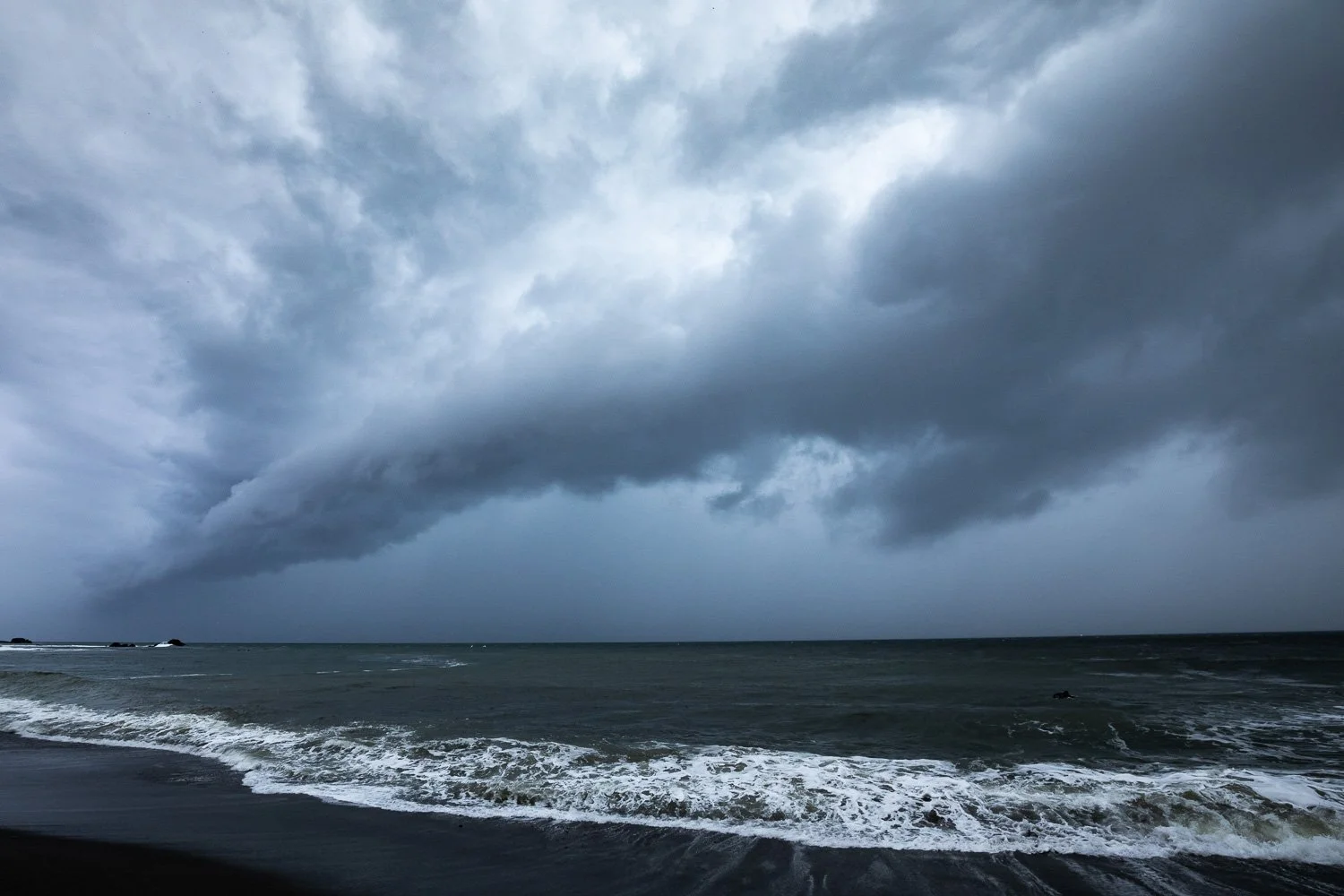 A towering anvil-topped thunderstorm cloud over water, the kind of severe cell driving the Brazil bomb cyclone red alert in Rio Grande do Sul.