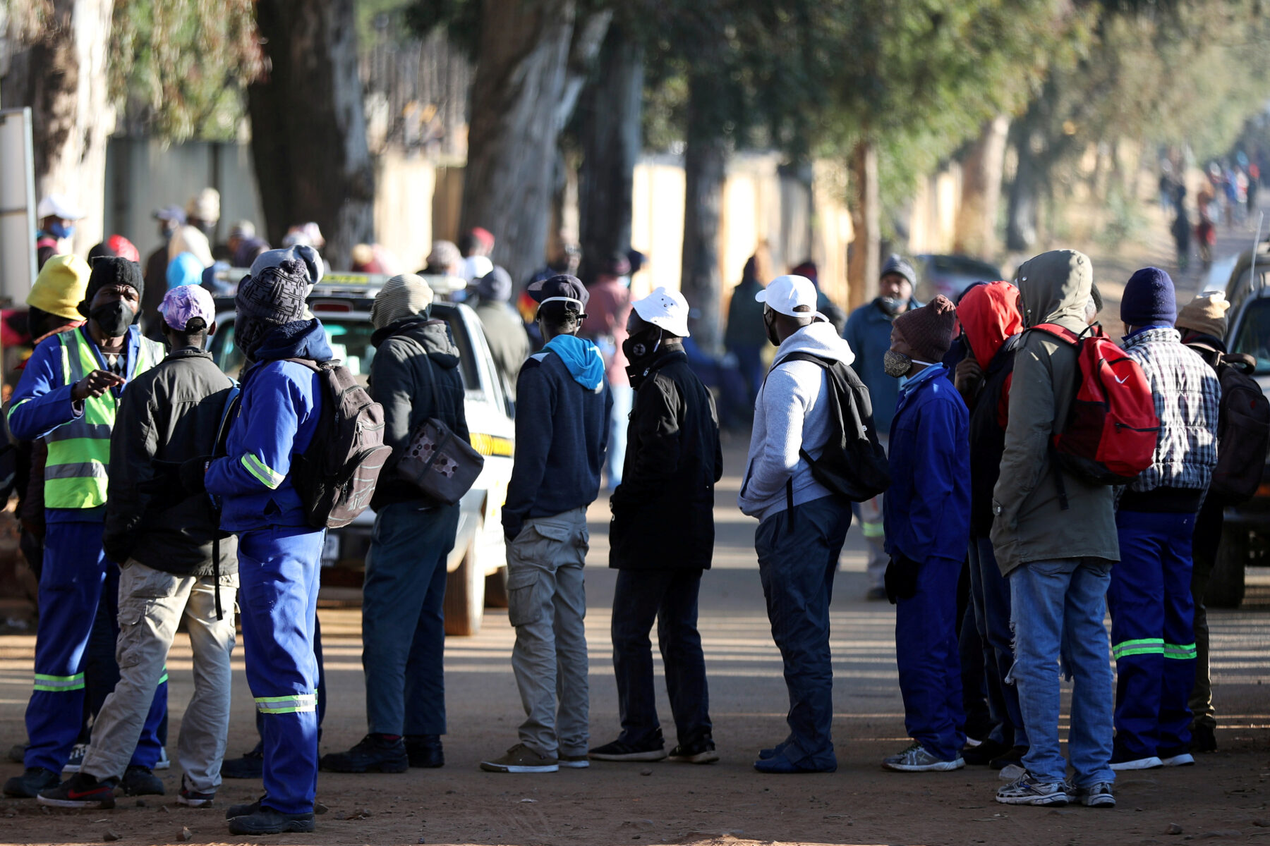 Job seekers stand outside a construction