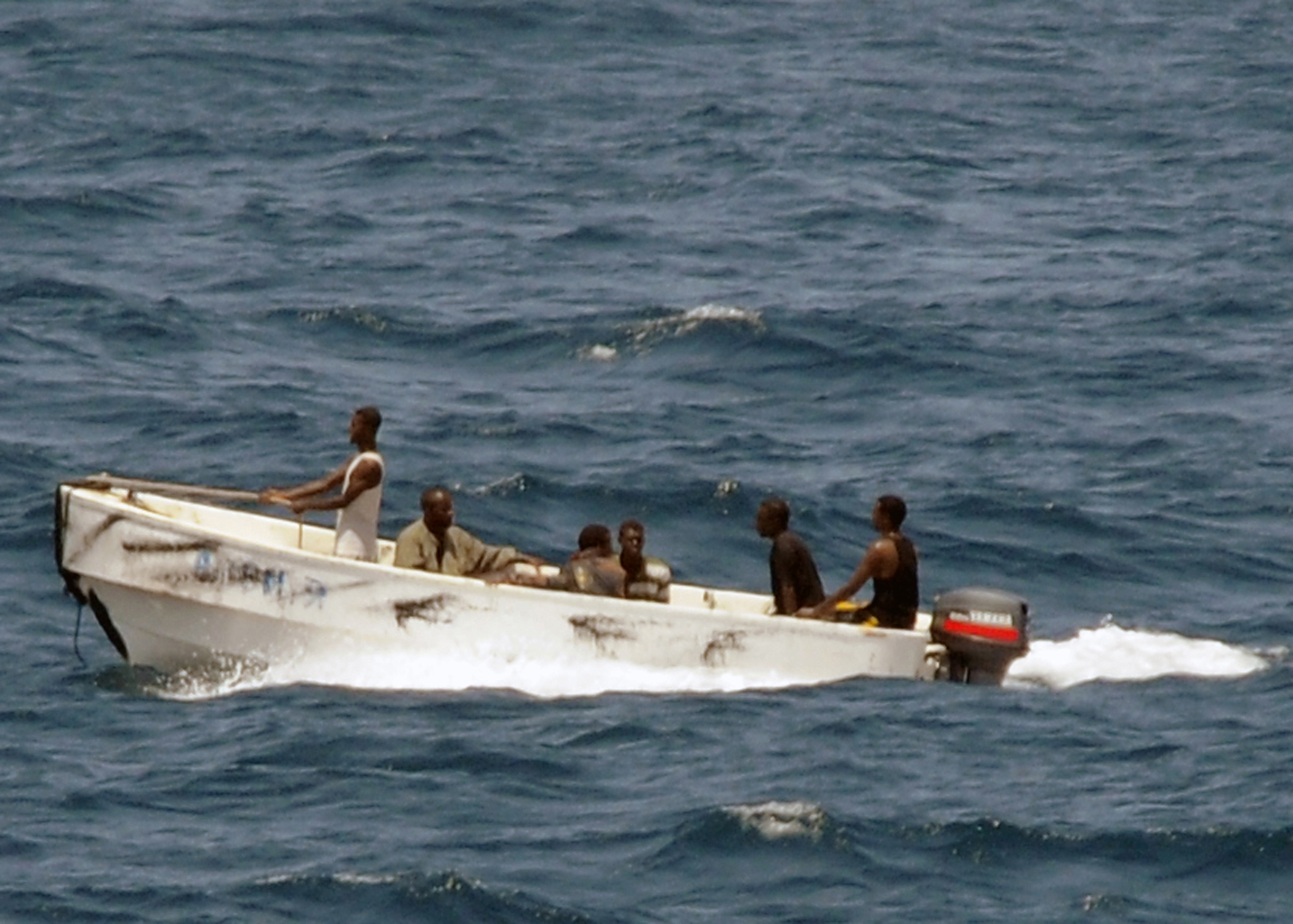 A small skiff carrying men leaves a hijacked merchant vessel off the Somali coast