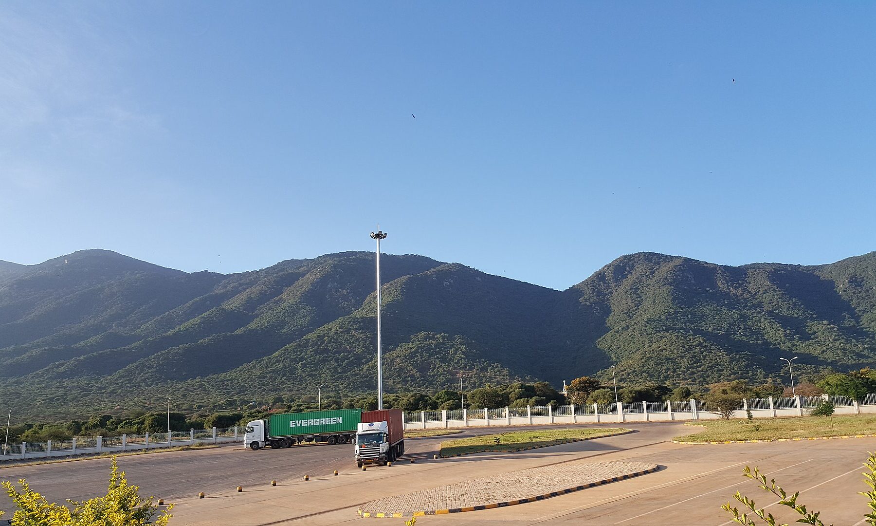 Cargo trucks at the Namanga border post between Kenya and Tanzania, with Ol-Donyo Orok mountain behind.