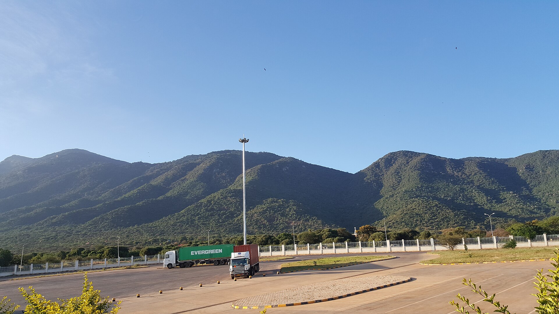 Cargo trucks at the Namanga border post between Kenya and Tanzania, with Ol-Donyo Orok mountain behind