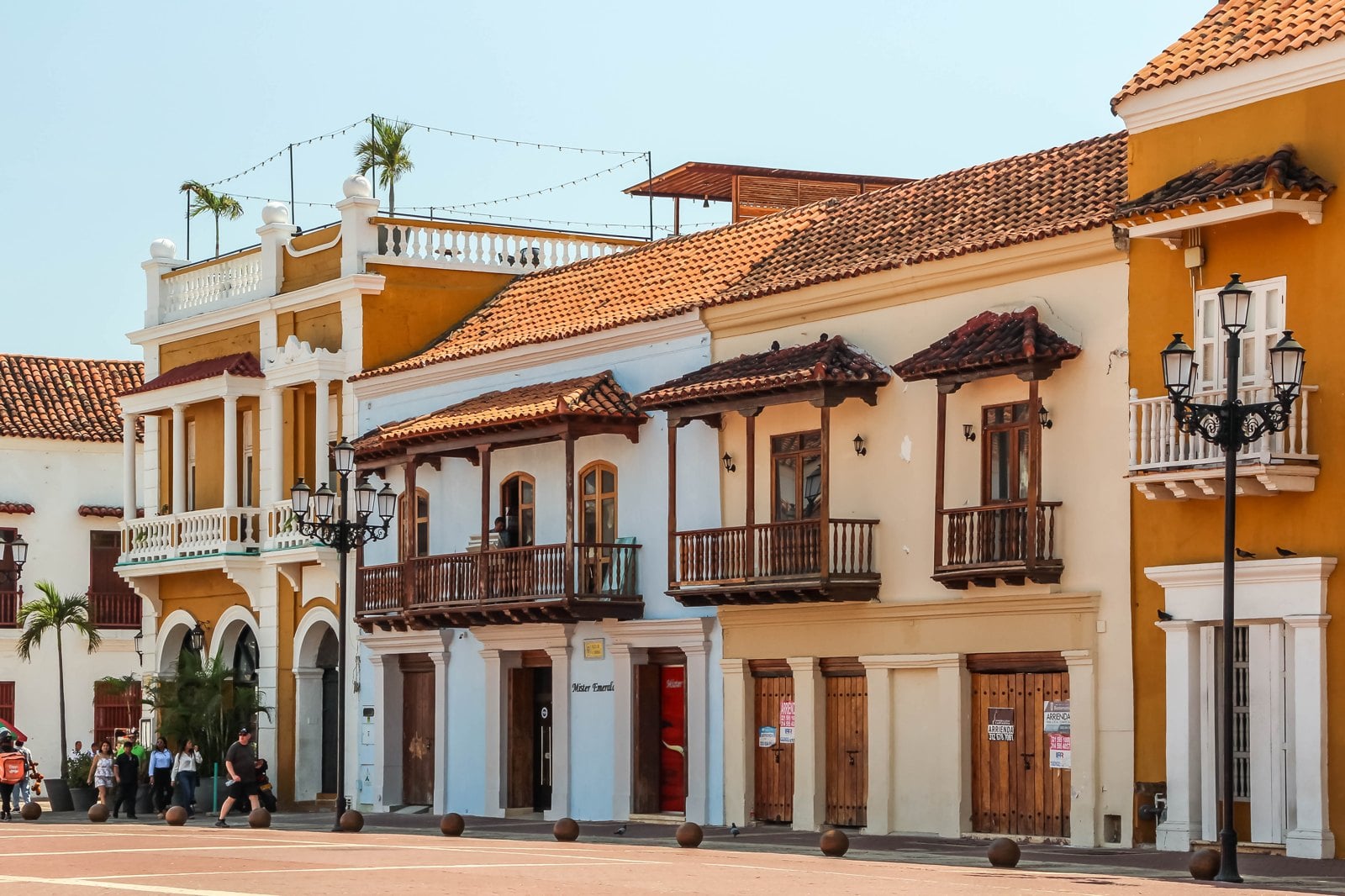A colonial street in Cartagena de Indias, with ochre and white facades and wooden balconies