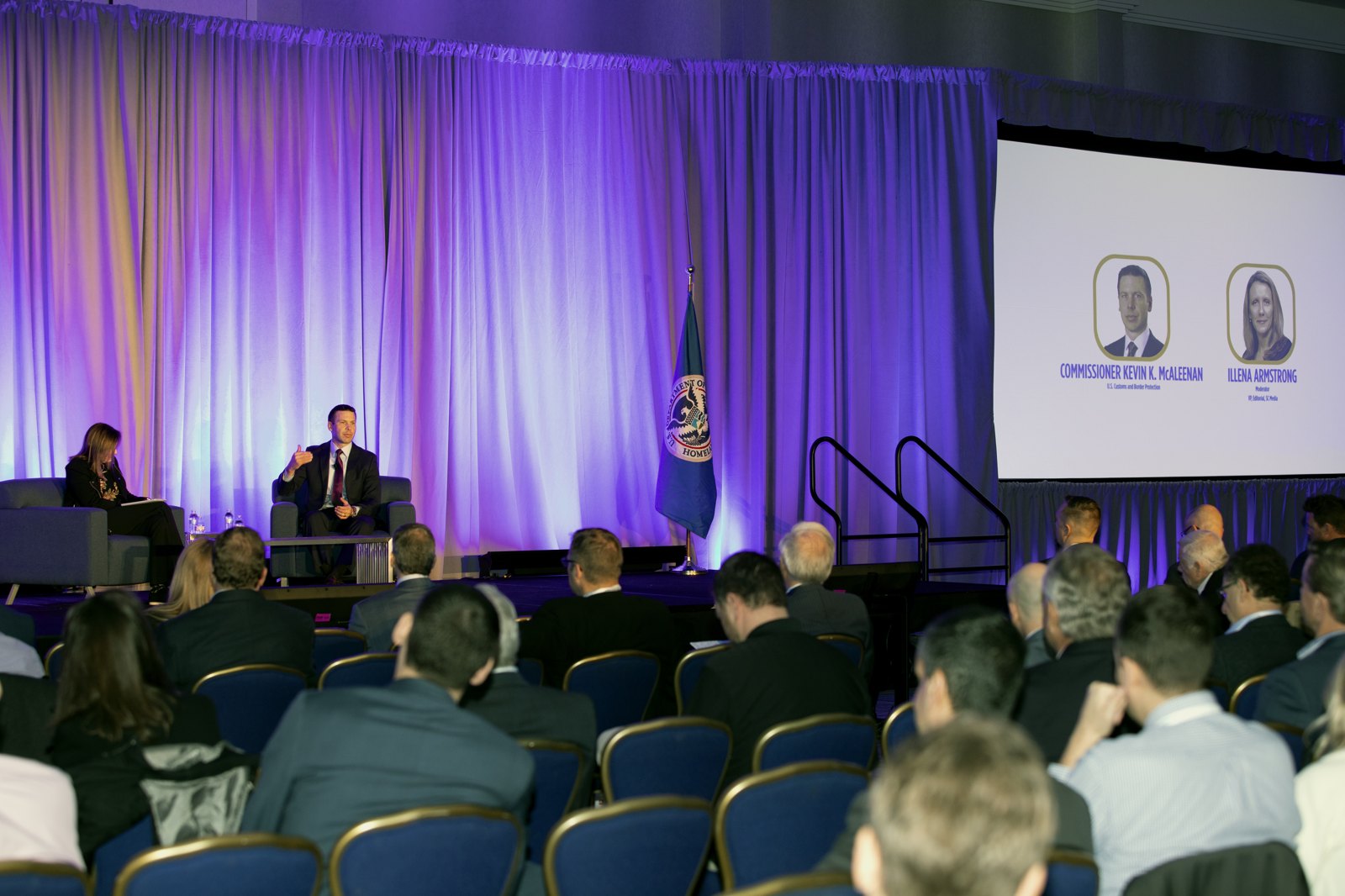 A conference stage before an audience.