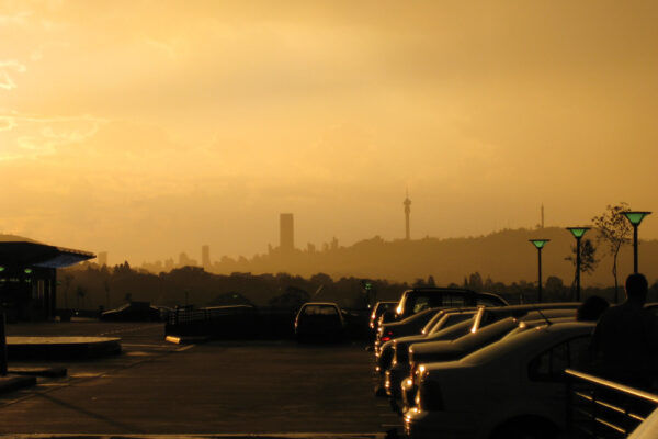 The Johannesburg skyline in silhouette at dusk seen across a car park