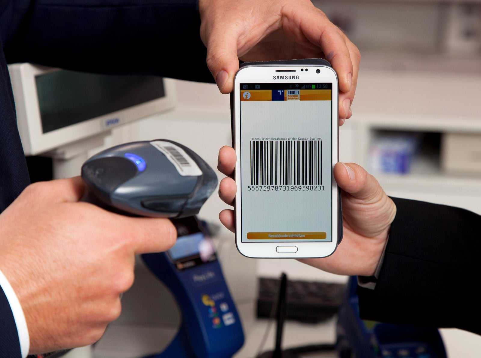A person paying with a smartphone at a checkout.