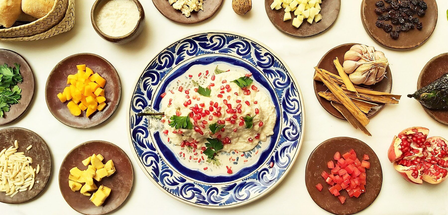chile en nogada - poblano chile topped with walnut sauce and pomegranate seeds