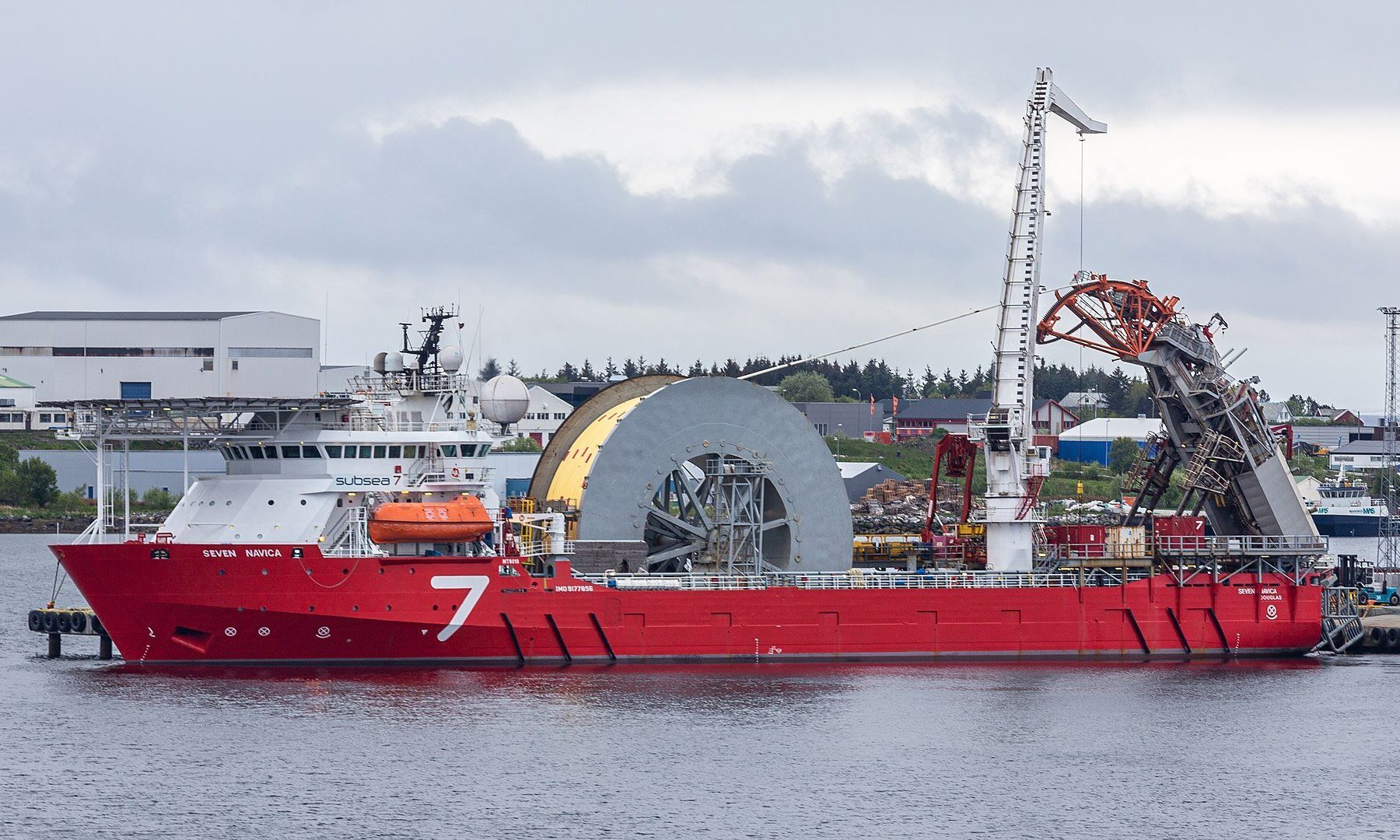 Vaca Muerta oil pipeline - subsea pipelay vessel with a large pipe reel moored at a port