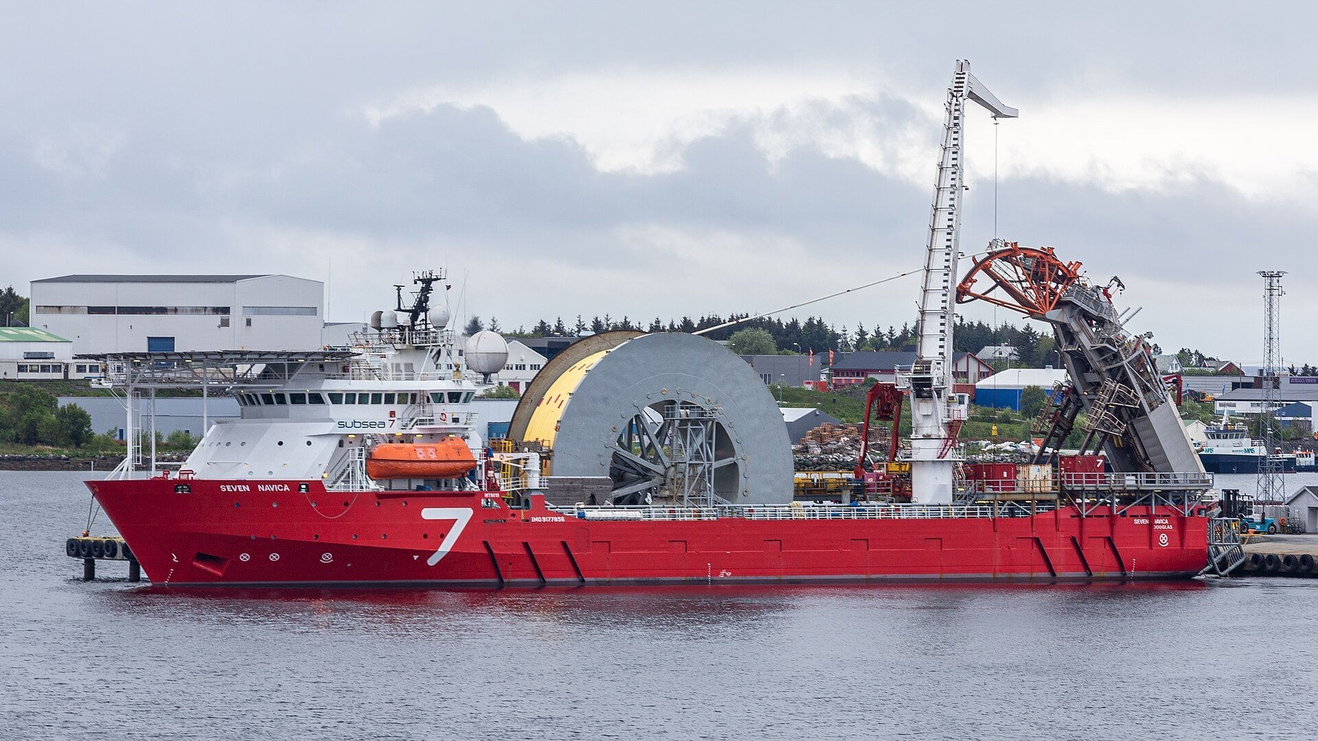 Vaca Muerta oil pipeline - subsea pipelay vessel with a large pipe reel moored at a port