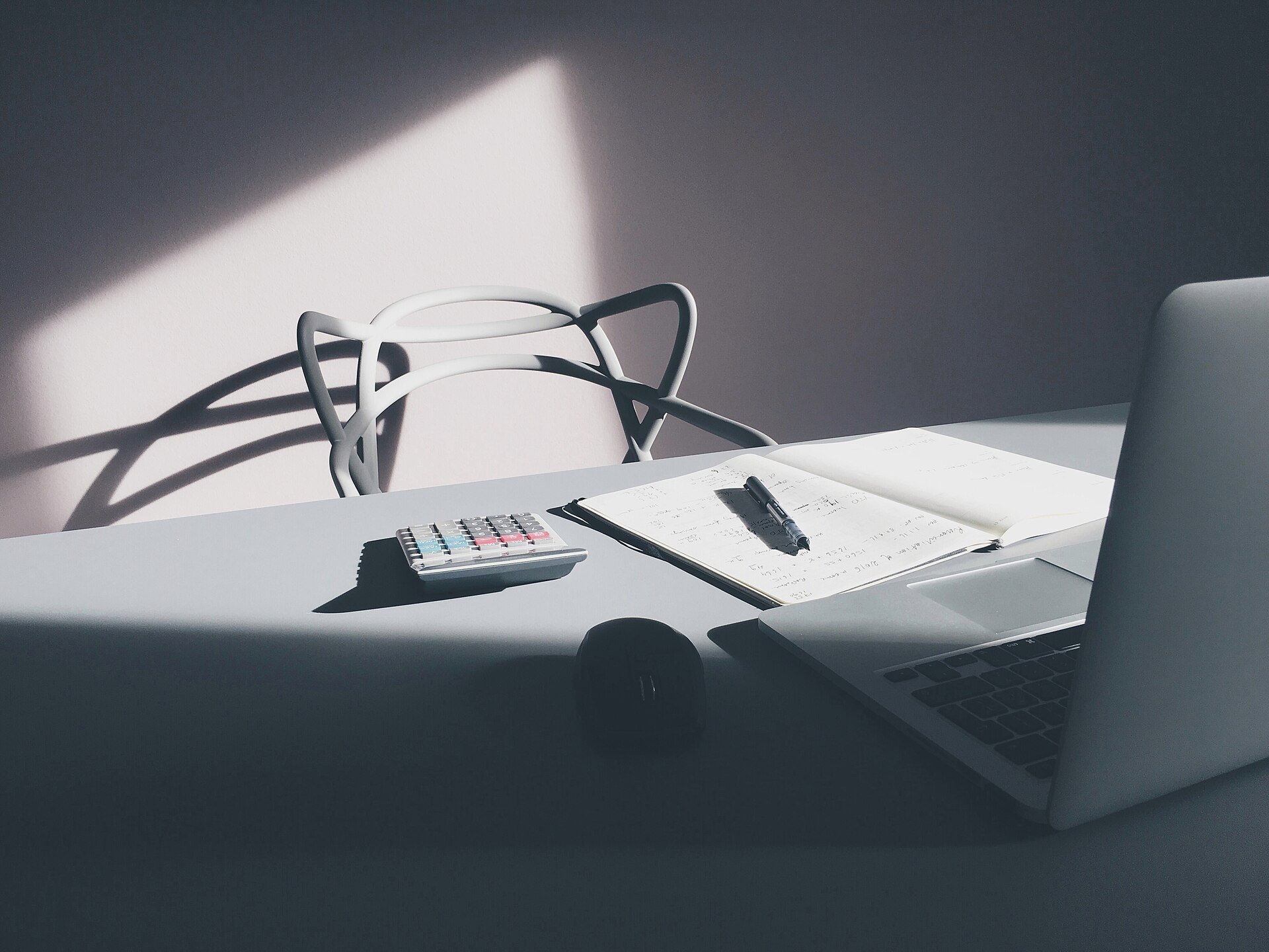 A laptop, notebook and calculator on a desk, illustrating what a SAT invoice in Mexico actually requires.
