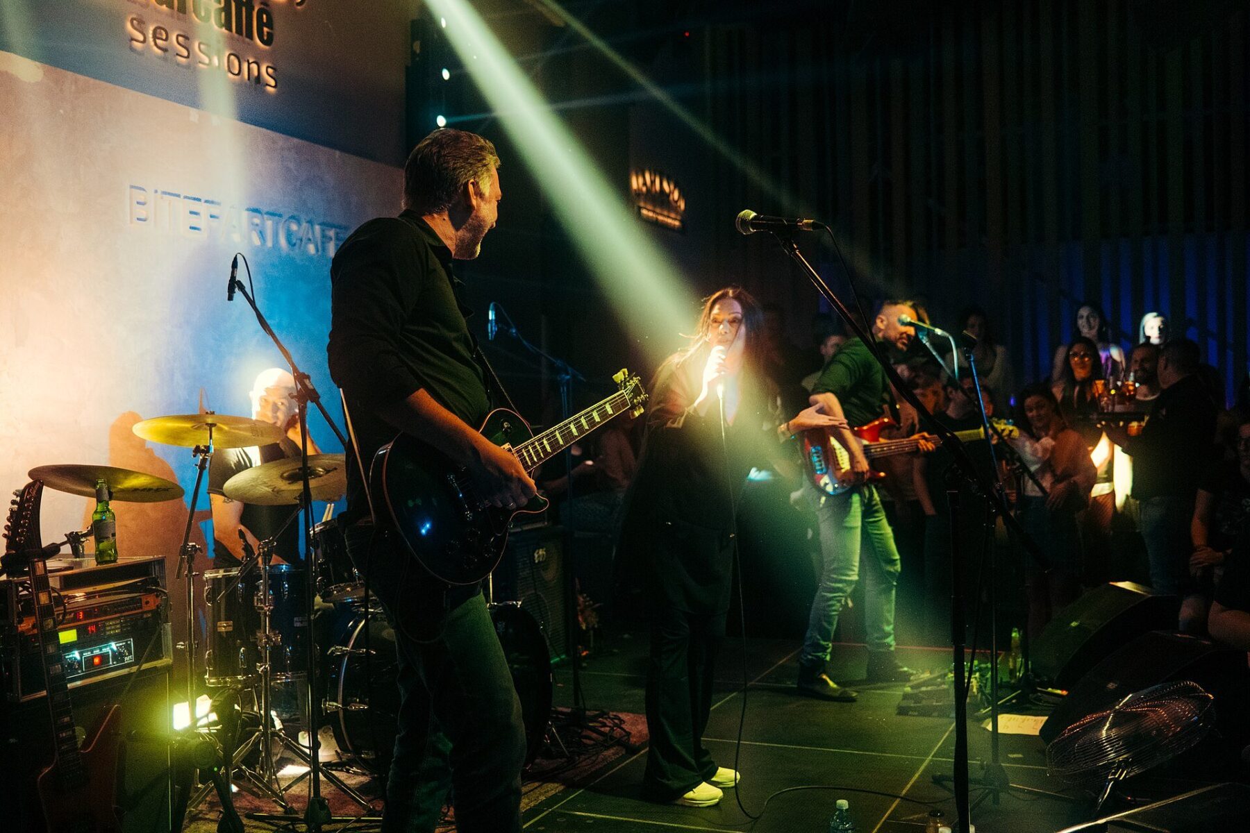 solidarity concert - a live band performs on a lit stage as the audience watches