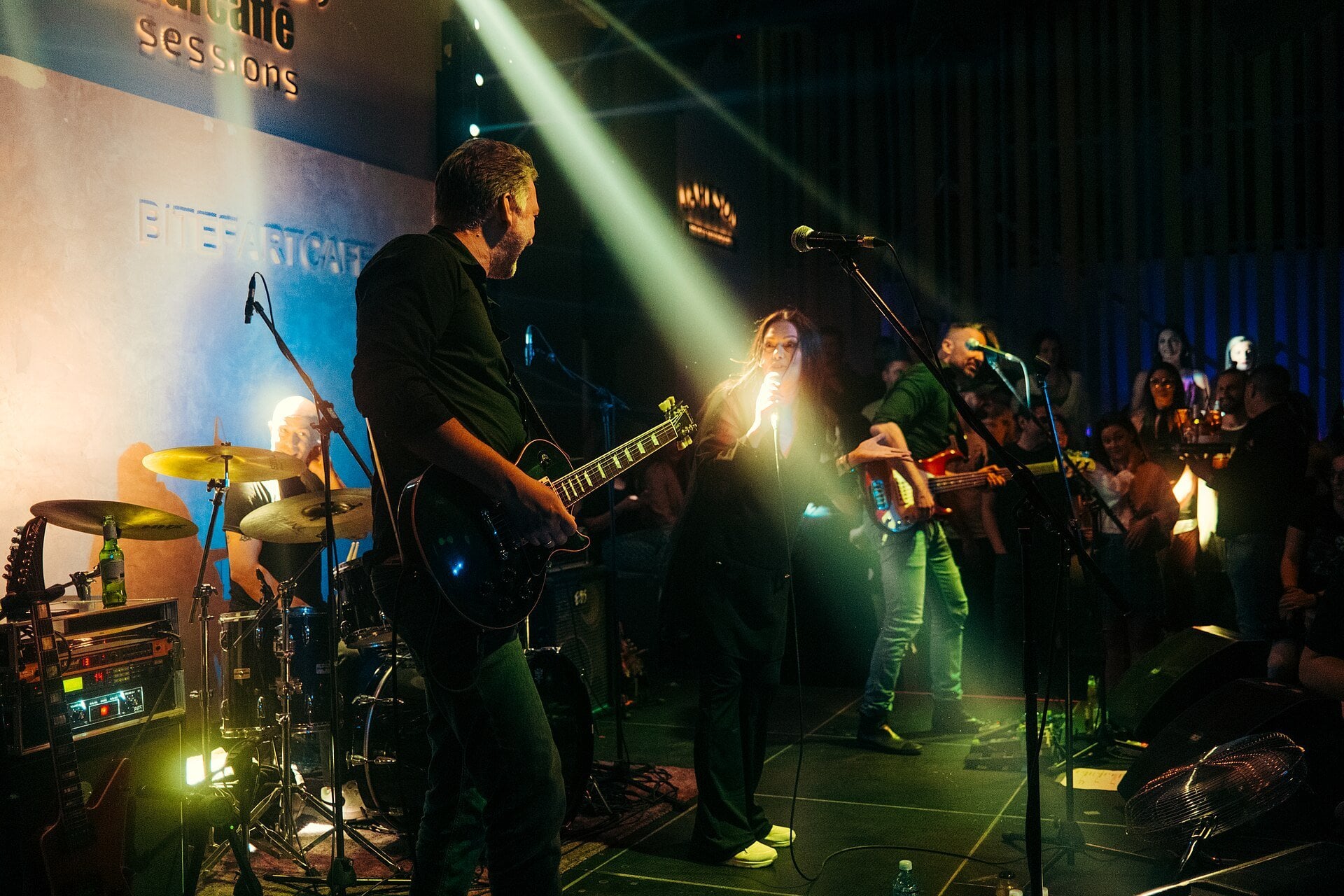 solidarity concert - a live band performs on a lit stage as the audience watches