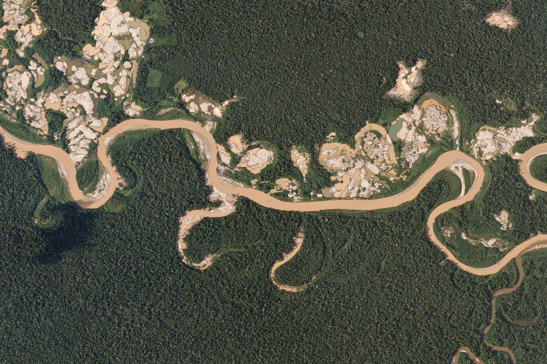 Ecuador illegal mining - aerial view of gold-mining scars along an Amazon river