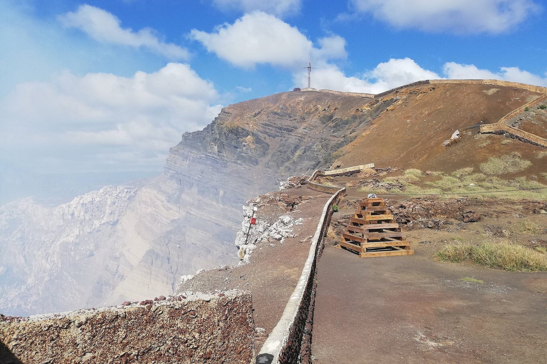 Masaya Volcano - the paved crater-rim viewing platform at Santiago crater with volcanic gas rising and the summit cross above