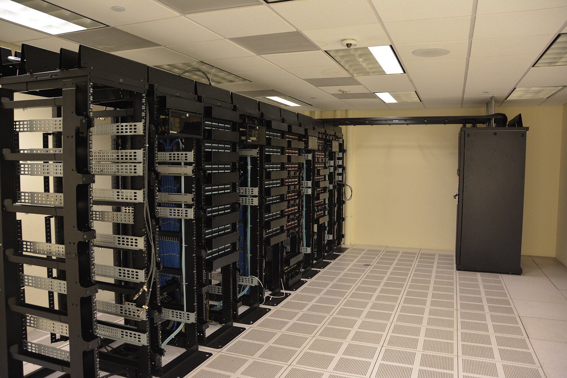 Mexico AI servers - rows of black server racks in a data center room with raised flooring