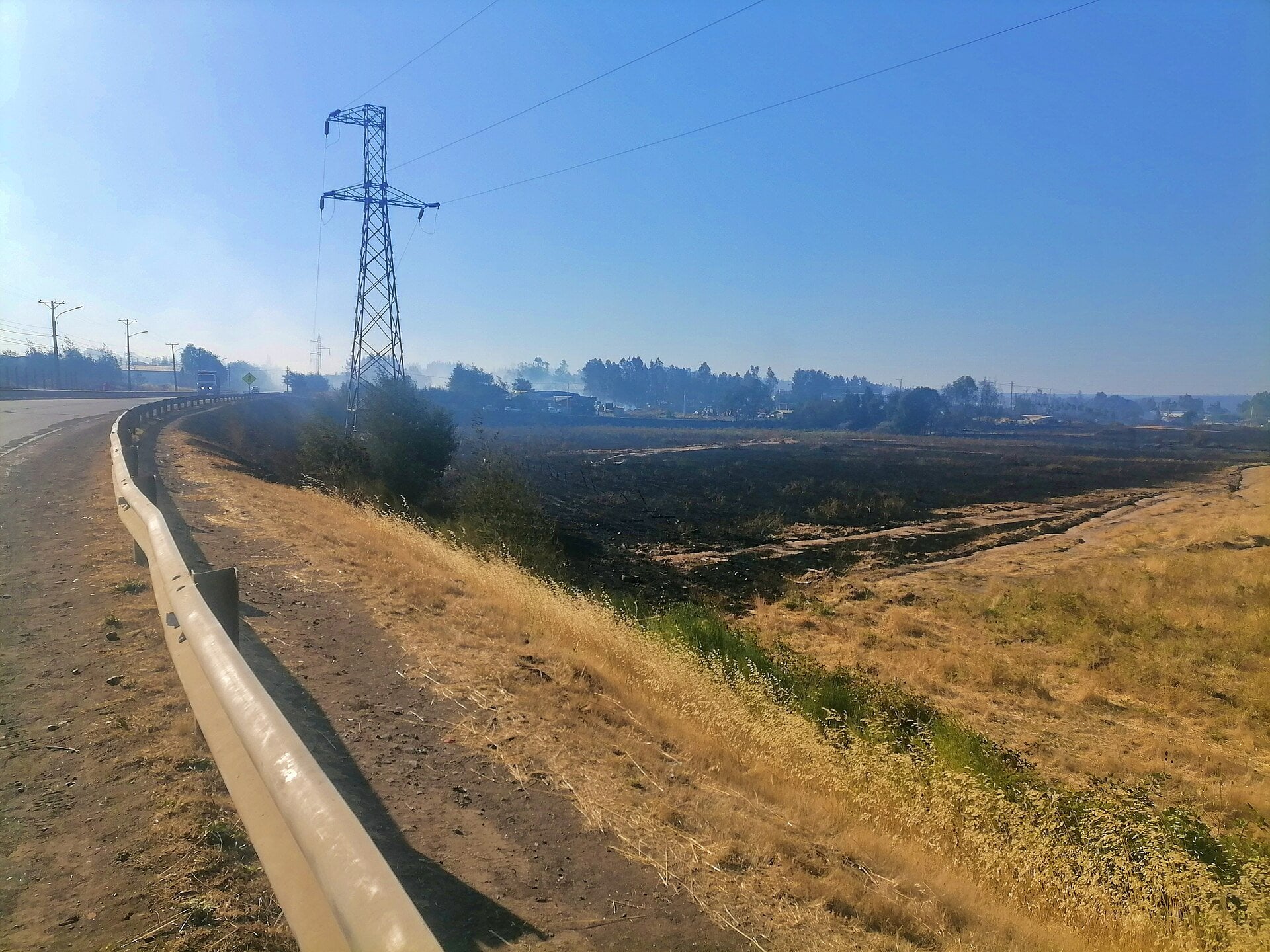 Tolima wildfires - scorched grassland and smoke beside a rural highway