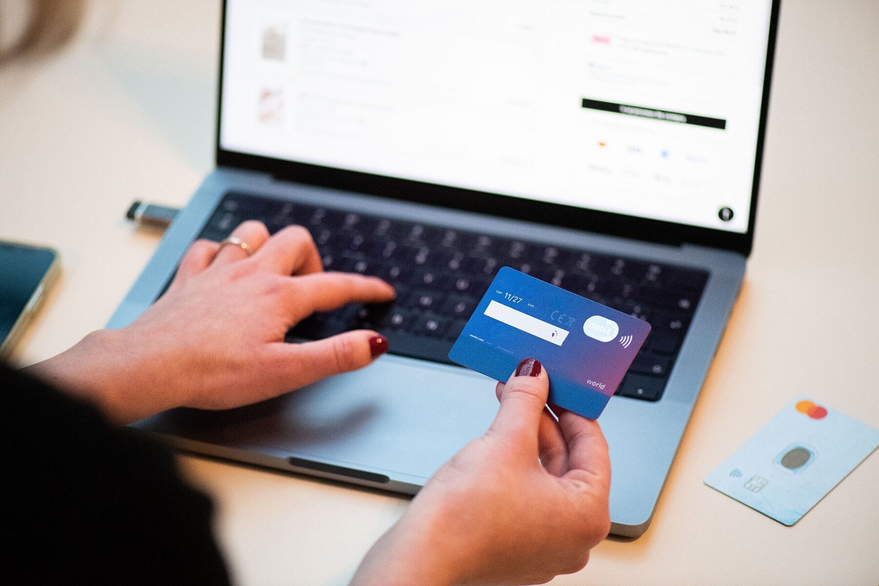 A person shopping online with a bank card and laptop, illustrating the cashback business of Méliuz, the fintech at the center of BTG Pactual's growing stake.