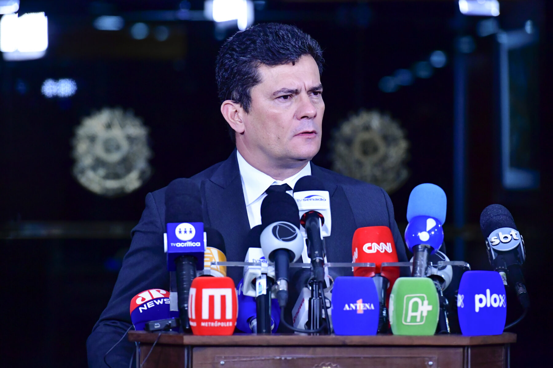 Sergio Moro at a campaign event, speaking into a microphone, with his gubernatorial bid in focus.