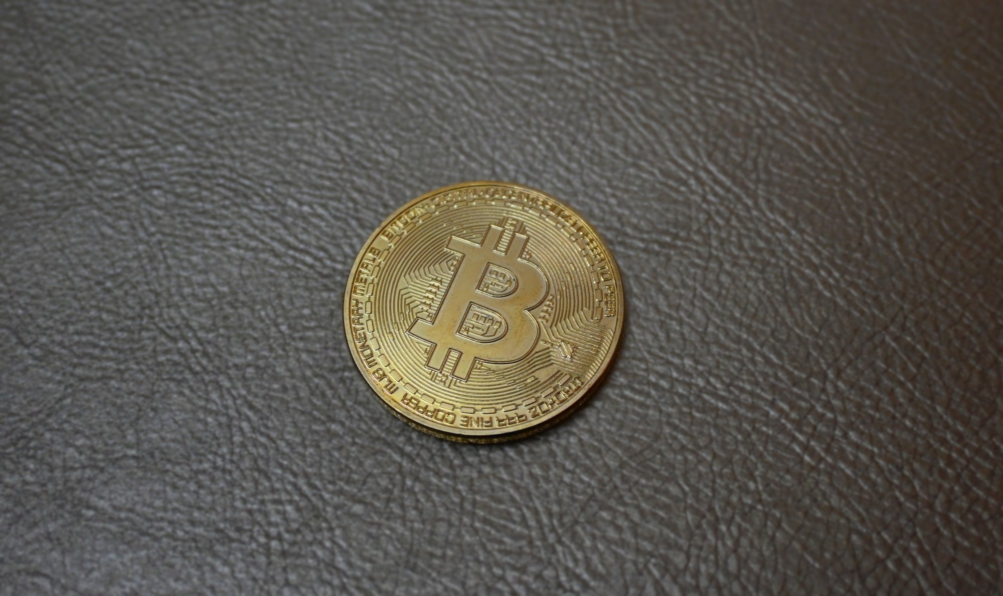 crypto custody — a physical Bitcoin token on a dark surface