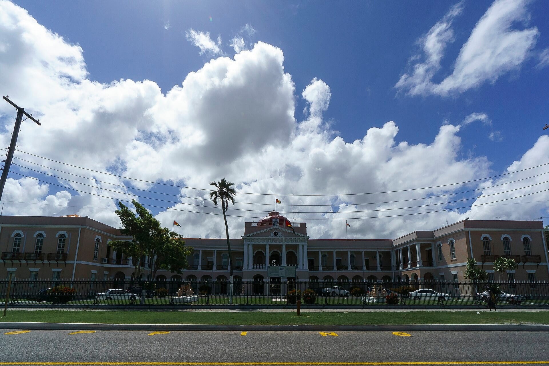 Guyana's Parliament Building in Georgetown, a colonnaded colonial block with a red dome and national flags