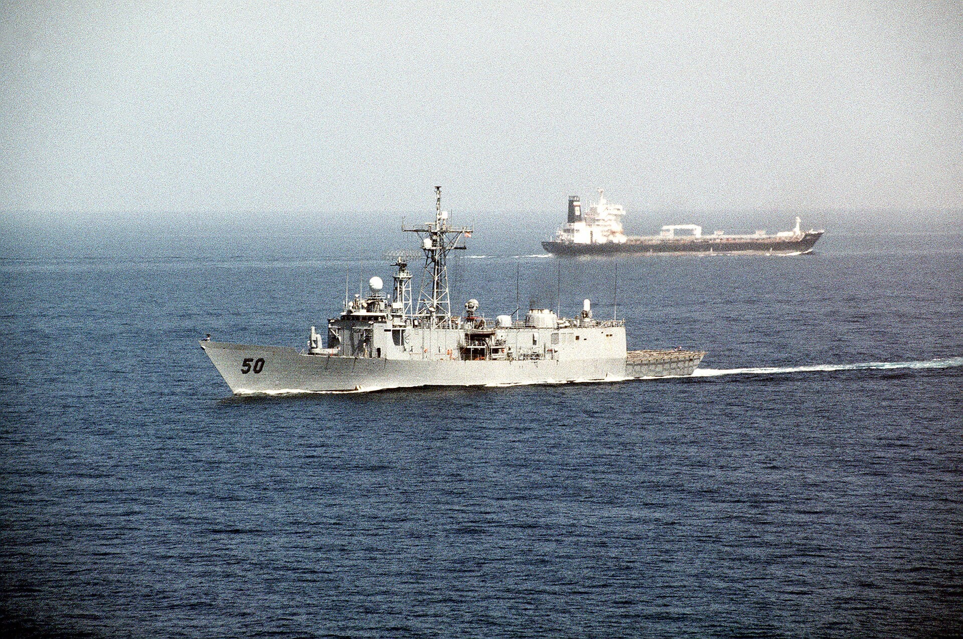 Strait of Hormuz — a US Navy frigate passes an oil tanker in the strait, archive photo