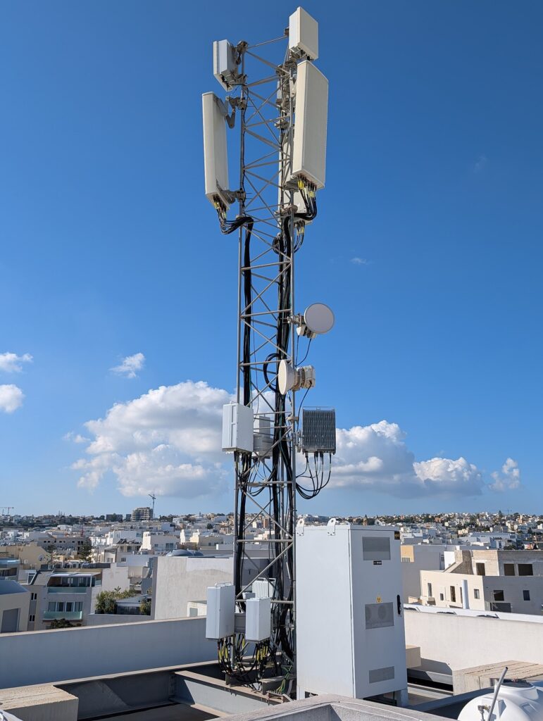 A tall mobile phone communications tower against a clear sky