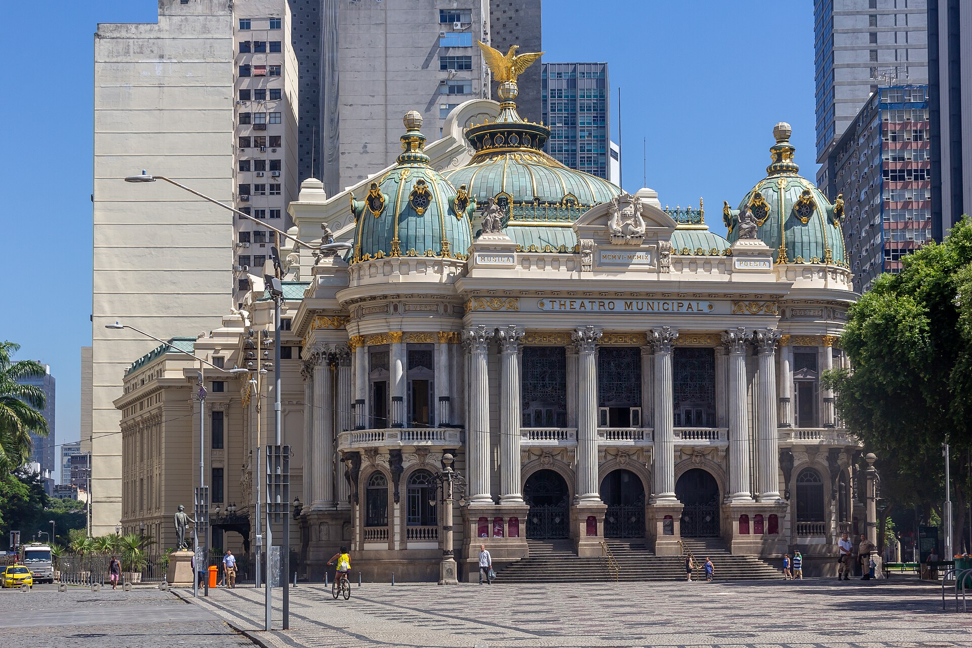 The ornate facade of the Theatro Municipal do Rio de Janeiro at Cinelandia under a blue sky