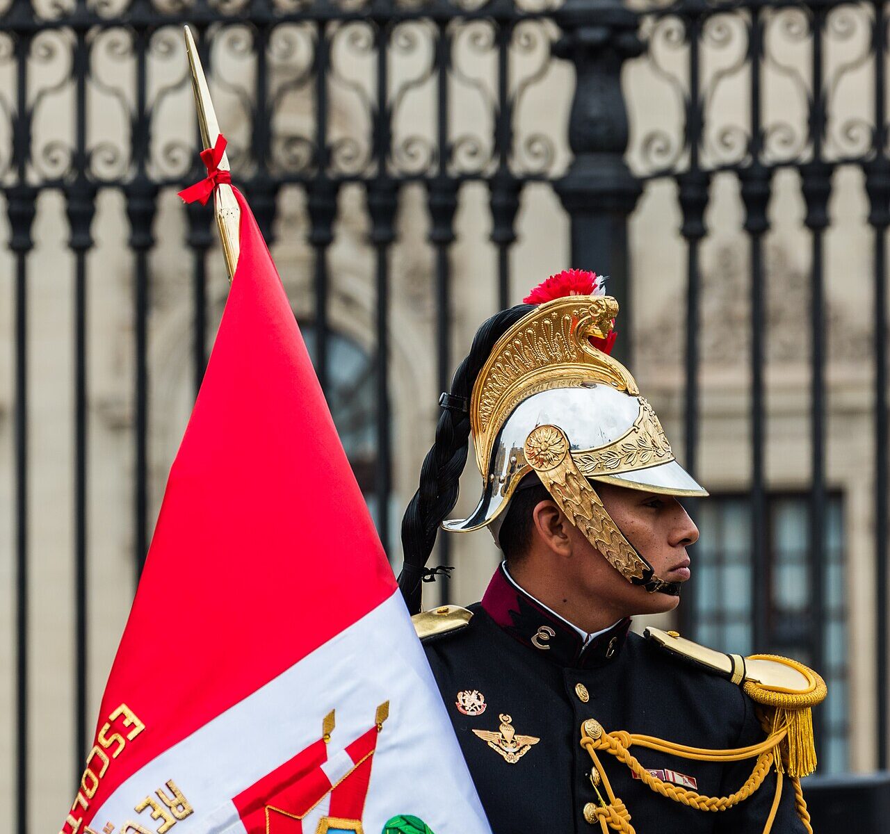 Presidential escort soldier with the Peruvian flag at Plaza de Armas in Lima, in front of the Government Palace