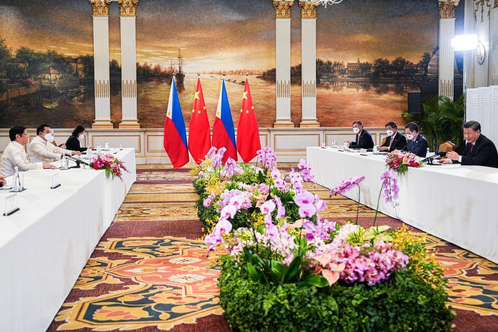 Chinese and Philippine delegations at a bilateral meeting in a hall with both national flags
