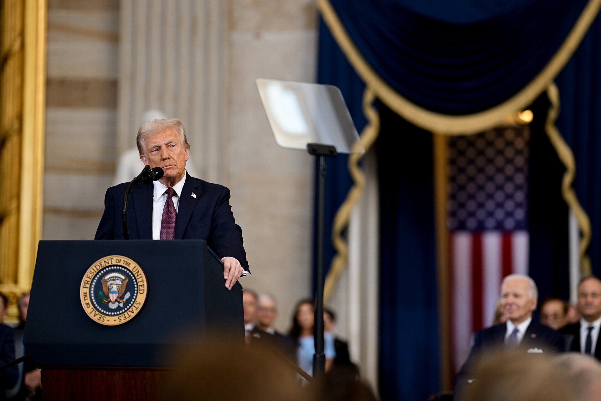 Donald Trump at a lectern bearing the presidential seal during his inauguration in the US Capitol