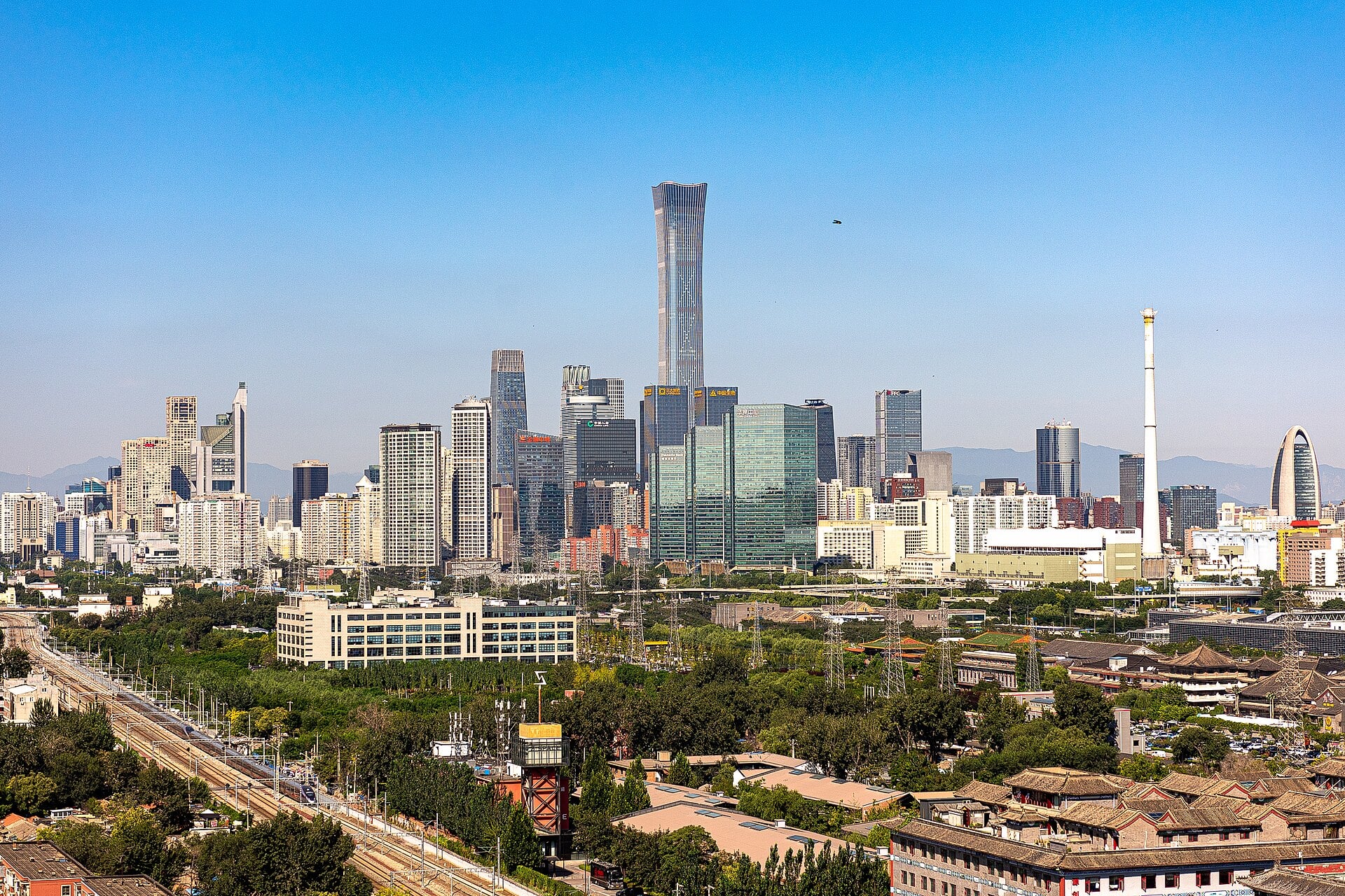 The Beijing central business district skyline with the China Zun tower rising above low-rise rooftops on a clear day.
