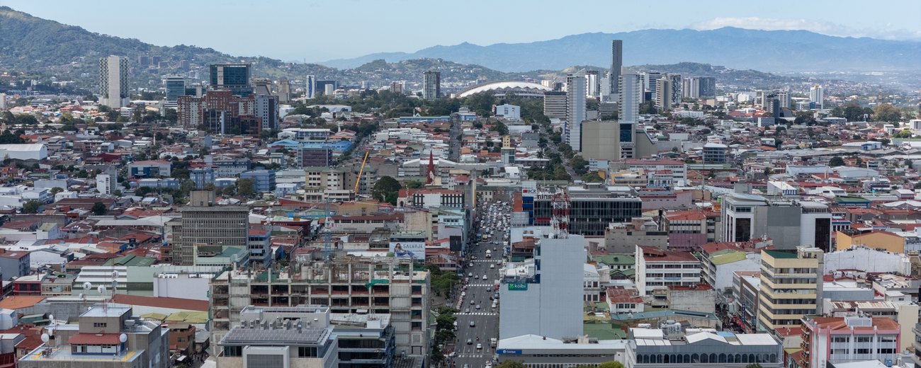 The low-rise centre of San Jose, Costa Rica, with office towers and the hills of the Central Valley behind.