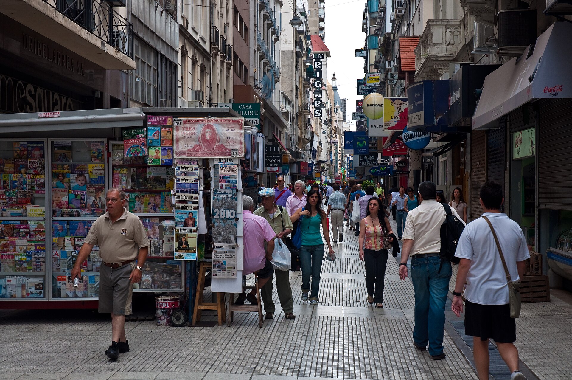 Shoppers walking past a news kiosk on Calle Florida, a pedestrian shopping street in central Buenos Aires