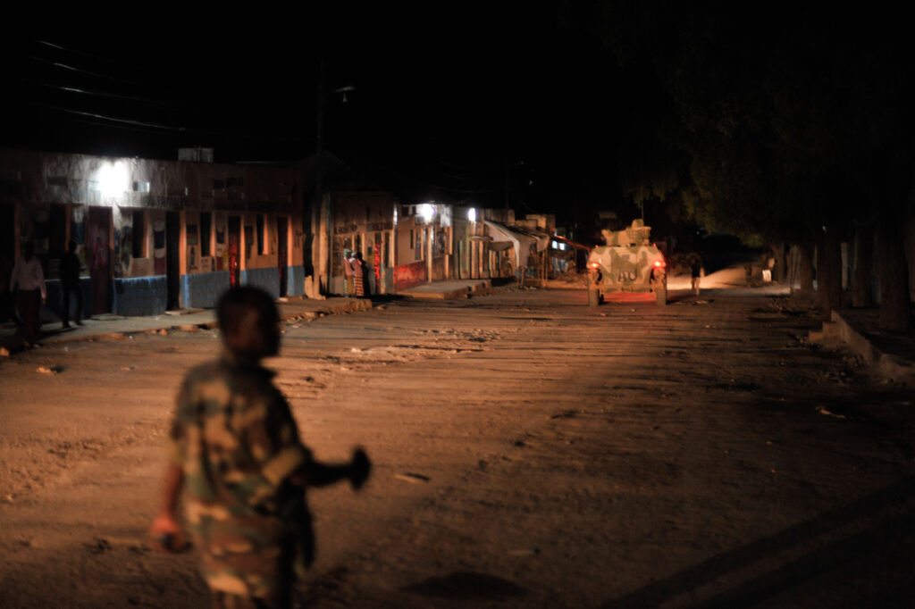 Soldier, armored vehicle on a street at night
