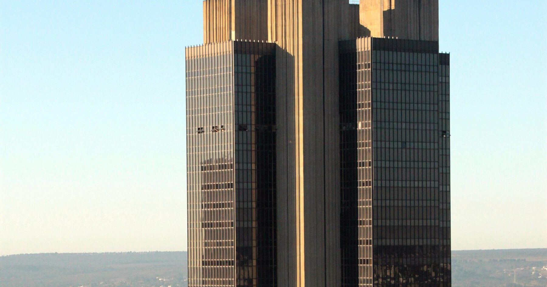 The headquarters tower of the Banco Central do Brasil in Brasília, its dark glass and concrete facade above the surrounding city.