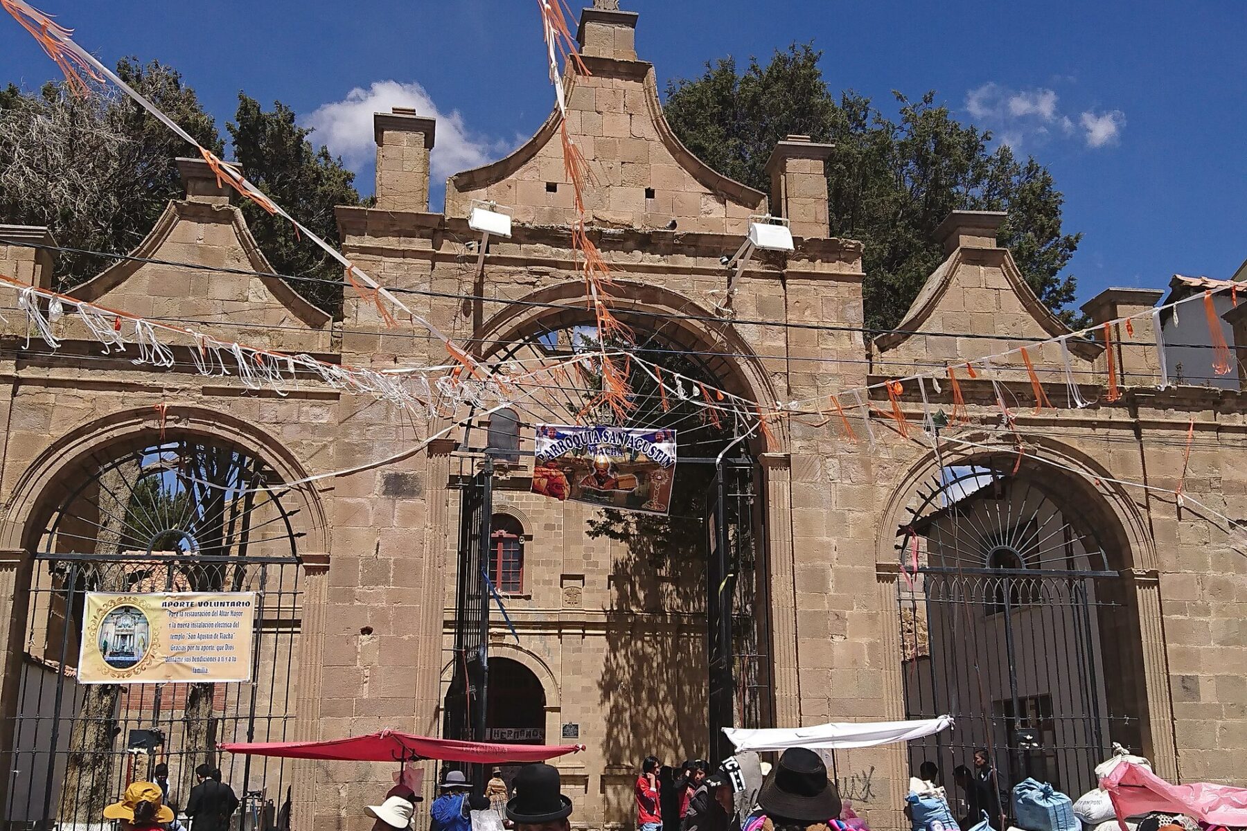 The colonial church of San Agustín in Viacha, Bolivia, with a street market outside
