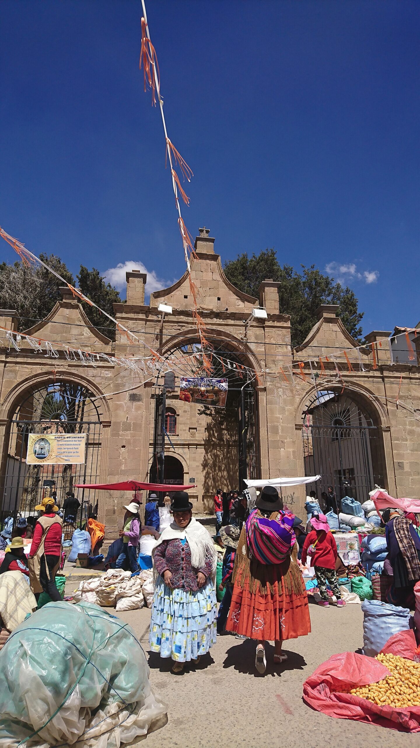 The colonial church of San Agustín in Viacha, Bolivia, with a street market outside